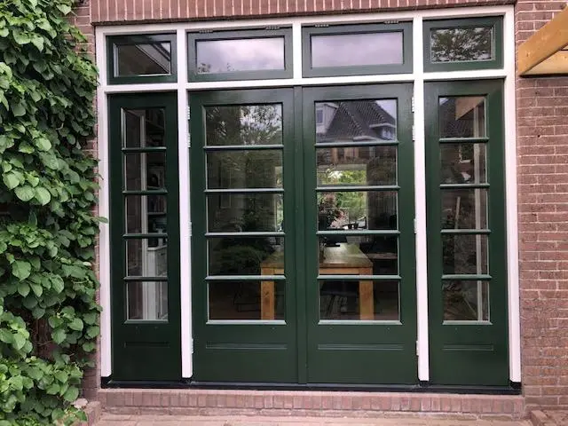 Groene houten deuren met zijpanelen